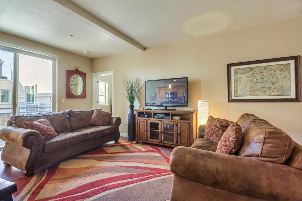uma sala de estar com 2 sofás e uma televisão de ecrã plano em Downtown Condo Near the Convention Center em Salt Lake City