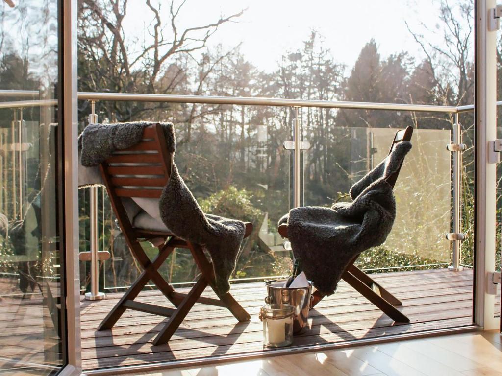 two birds standing on a deck with a chair at Kinness Lodge - Uk39595 in Strathkinness