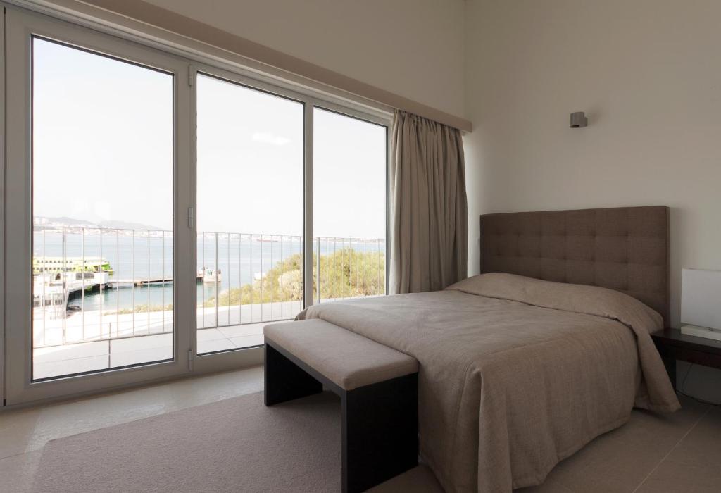 a bedroom with a bed and a large window at Troia Residence by The Editory - Apartamentos Marina in Troia