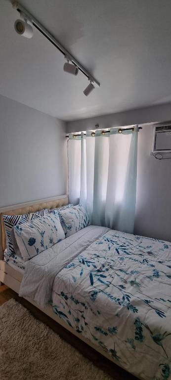 a bedroom with a bed with blue flowers on it at Mikaela's Crib- 1 Bedroom flat @ Arezzo Place Condominium in Davao City