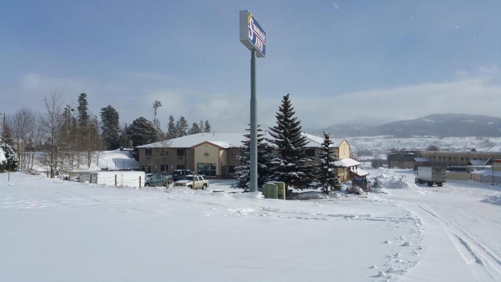 un letrero de la calle en un poste en la nieve en New Summit Inn, en Frisco