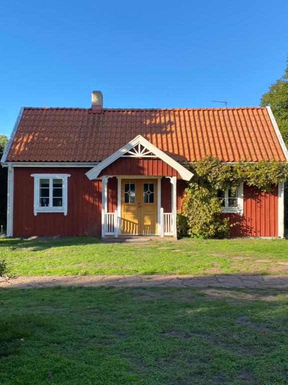 uma casa vermelha com um telhado vermelho em Bo i egen stuga på härlig ölandsgård em Köpingsvik