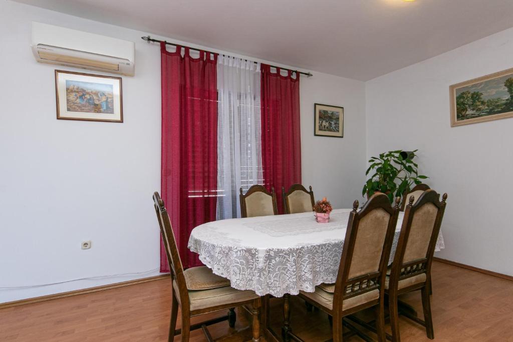a dining room with a table and a red curtain at Apartments with a parking space Gradac, Makarska - 14708 in Gradac