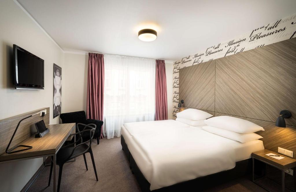 a hotel room with a bed and a desk at elaya hotel vienna city west in Vienna