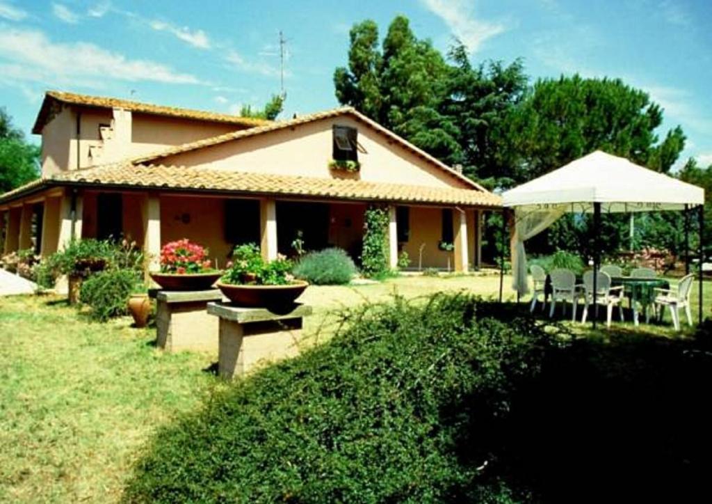 馬薩馬里蒂馬的住宿－哥里貝托農家樂，院子里带桌子和雨伞的房子