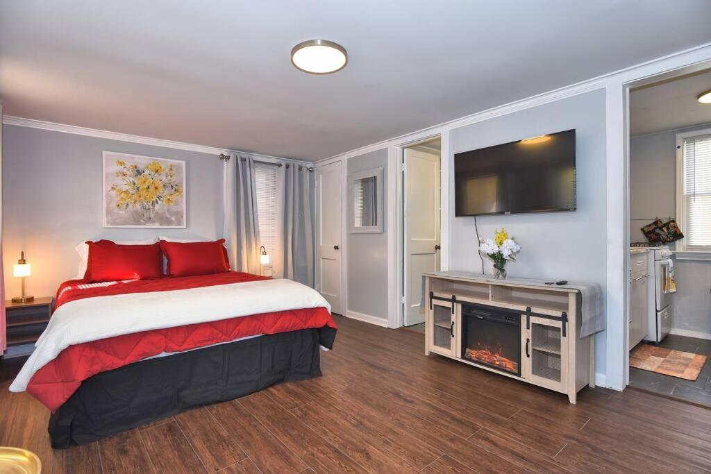 1 dormitorio con 1 cama con almohadas rojas y TV en BLUE FLAMINGO'S ADORABLE GUEST HOUSE -TU-Cherry St-Expo-Downtown-11t en Tulsa