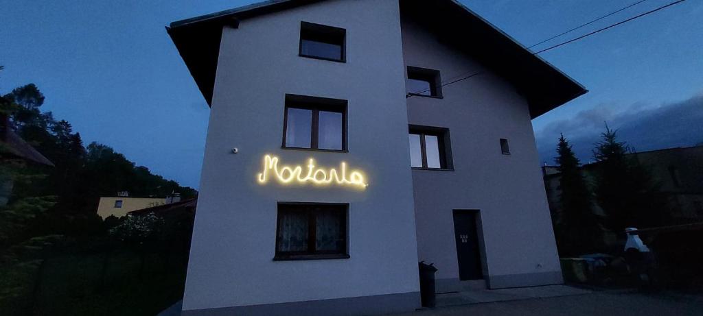 维斯瓦APARTAMENTY MONTANIA WISŁA的一座白色的建筑,上面标有好莱坞的标志