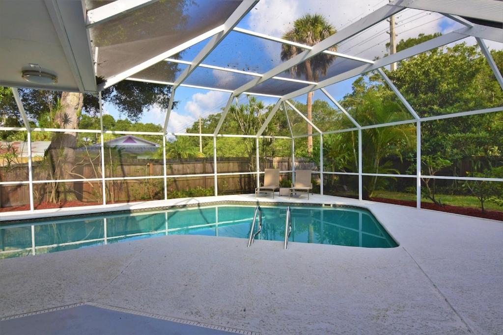 an indoor swimming pool with a large glass ceiling at Clematis House near Arlington Park with Heated Pool in Sarasota