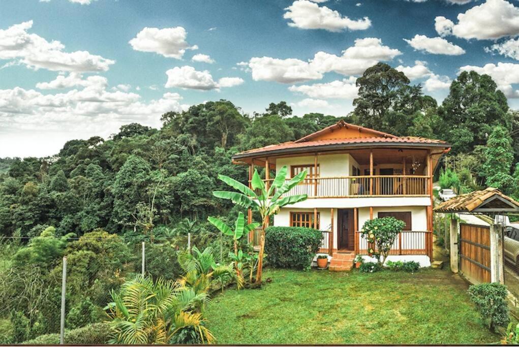 una casa en medio de un campo con árboles en Mirador de los Vientos, en Manizales