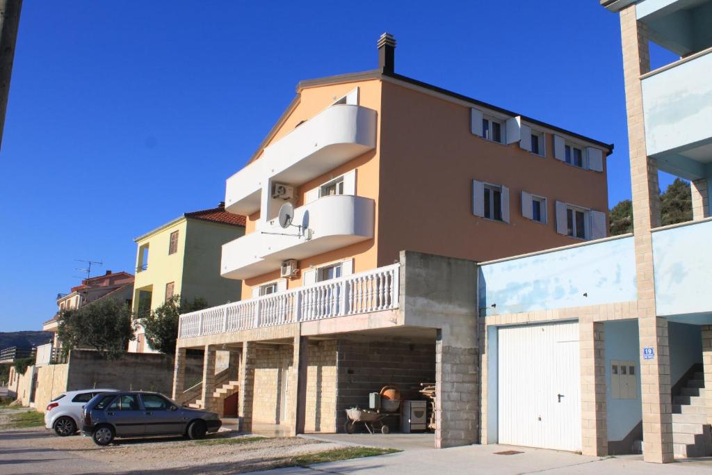 a building with a car parked in front of it at Apartments with a parking space Seget Vranjica, Trogir - 8507 in Seget Vranjica