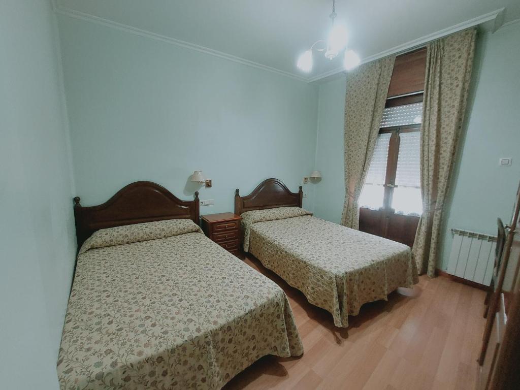1 dormitorio con 2 camas y ventana en Hotel Chipén, en Vigo