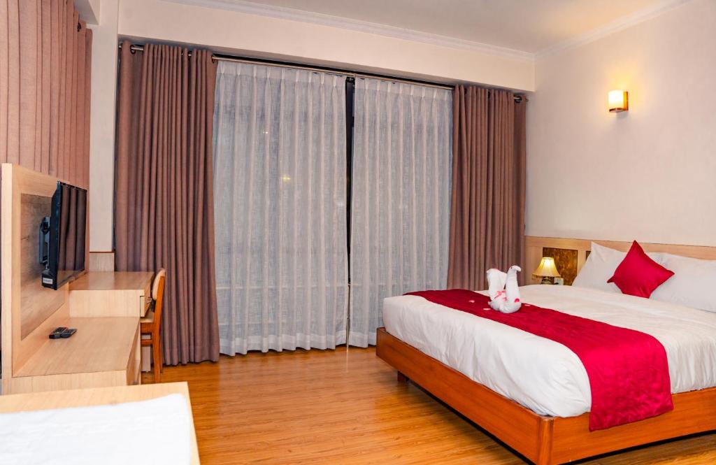 Postel nebo postele na pokoji v ubytování Drishya Hotel