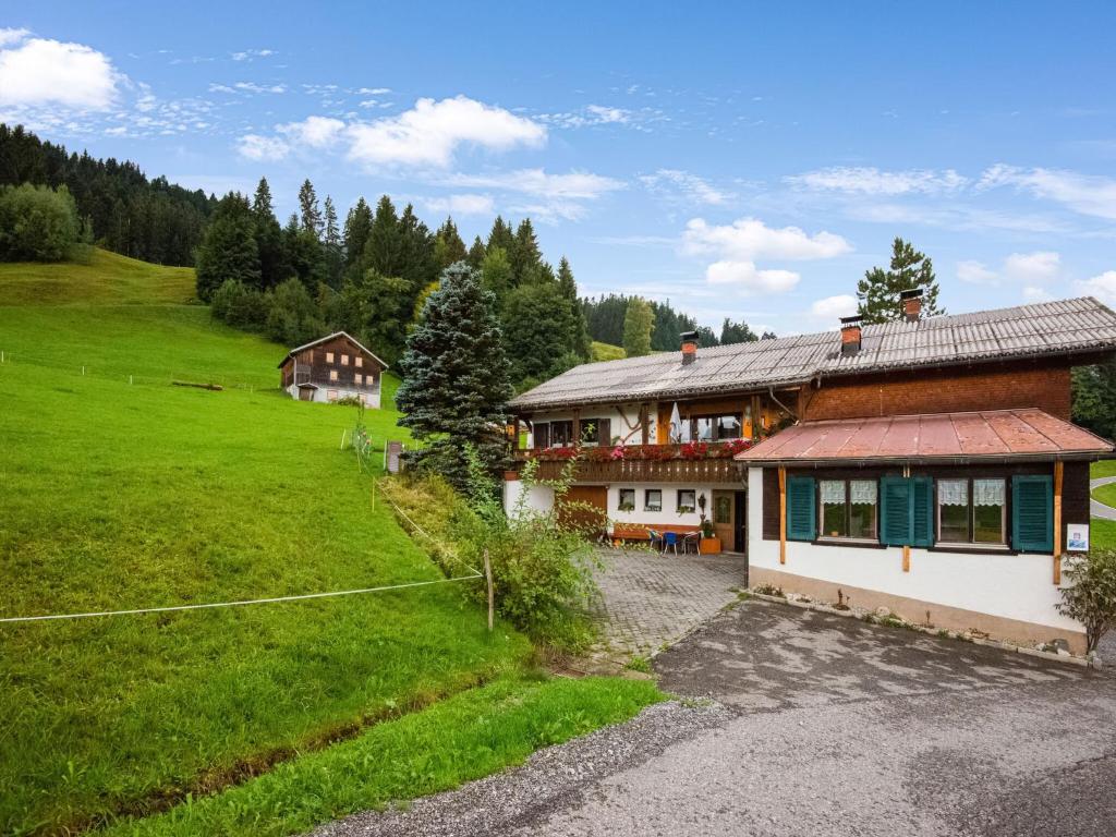 a house in the middle of a green field at Vintage Holiday Home in Vorarlberg near Ski Area in Schwarzenberg