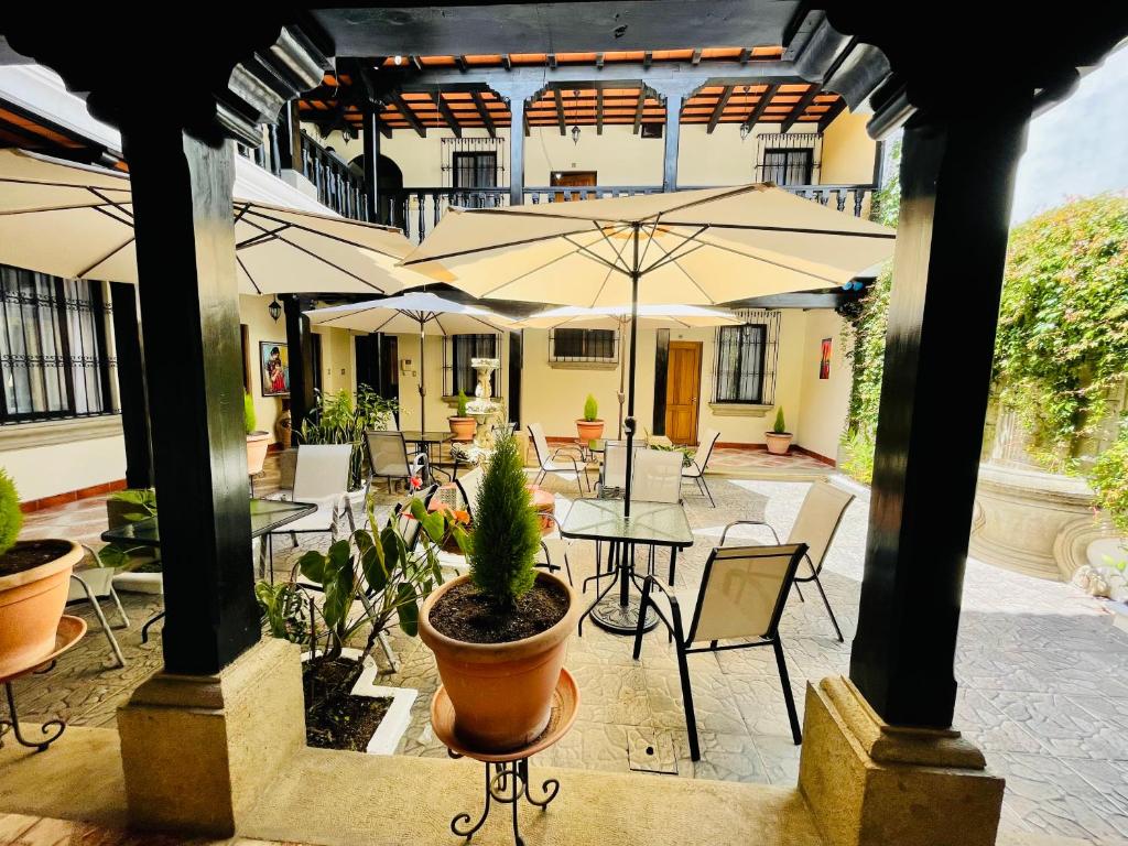 an outdoor patio with tables and chairs and umbrellas at Real Marquez Hotel in Antigua Guatemala