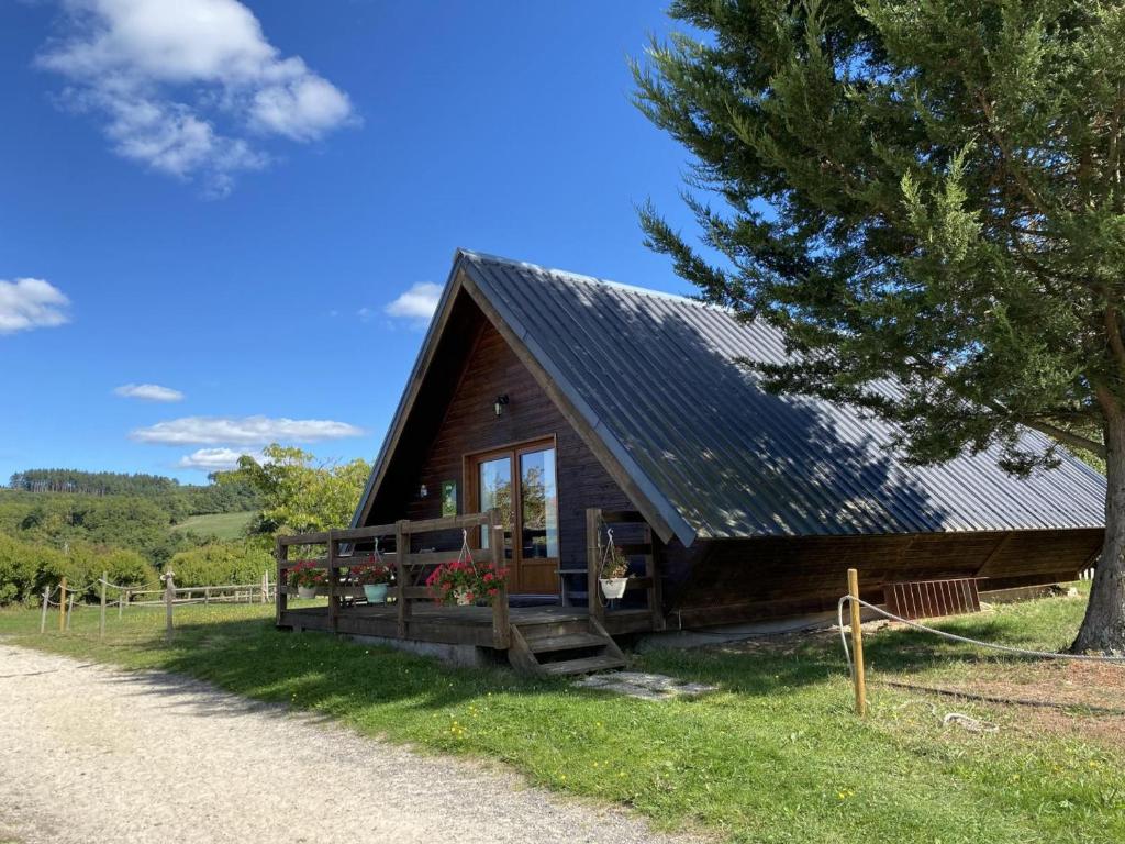 Cabaña de madera con porche y árbol en Gîte Le Vernet, 3 pièces, 5 personnes - FR-1-489-274, en Le Vernet