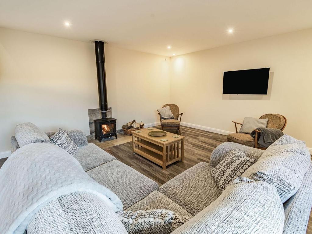 a living room with two couches and a fireplace at Brick Kiln Cottage in Burton Overy