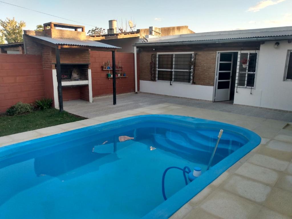 a blue swimming pool in front of a house at Abuelo Coqui in Ramallo