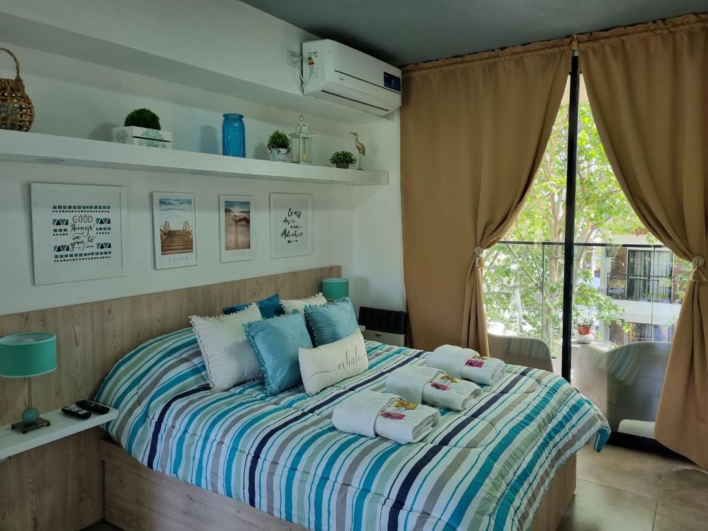 a bedroom with a bed with pillows and a window at Departamento Vera Mujica 3 cochera propia incluida in Rosario