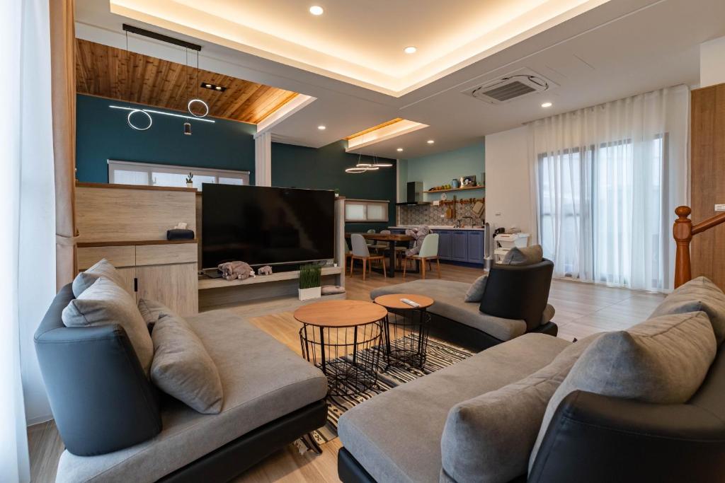 a living room with a couch and a television at FUN Style Homestay in Zhuangwei