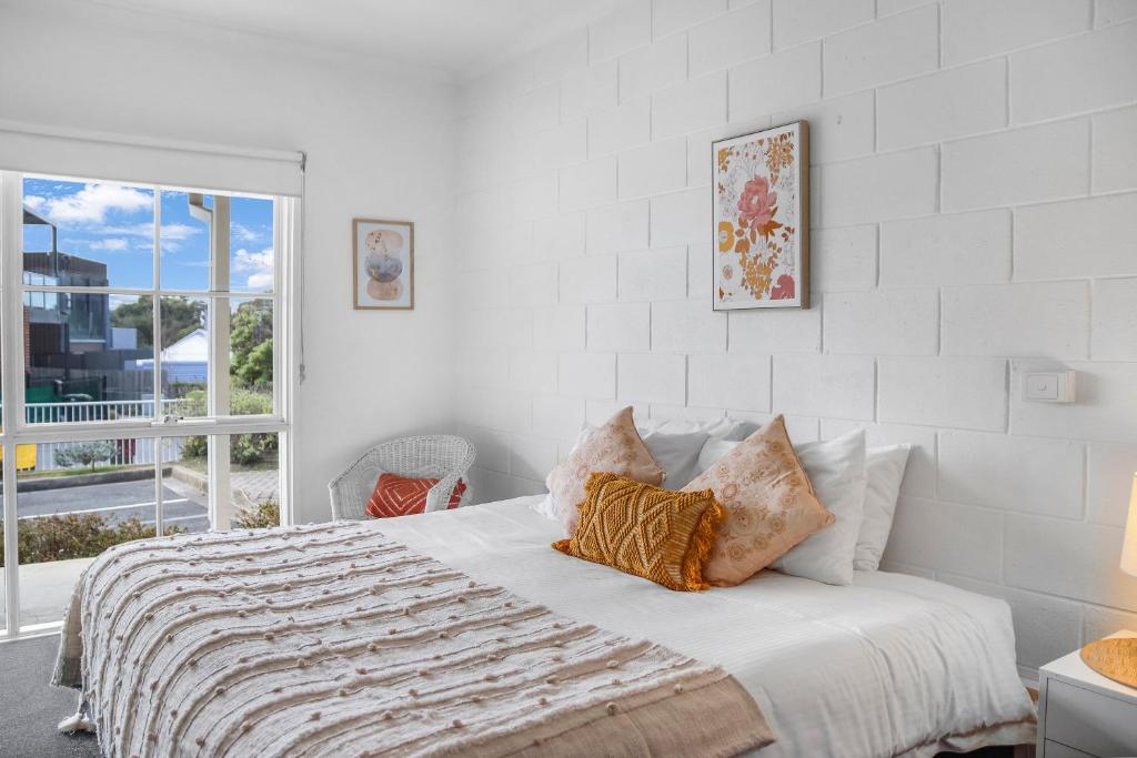 a white bedroom with a bed and a window at Geelong CBD Accommodation in Geelong