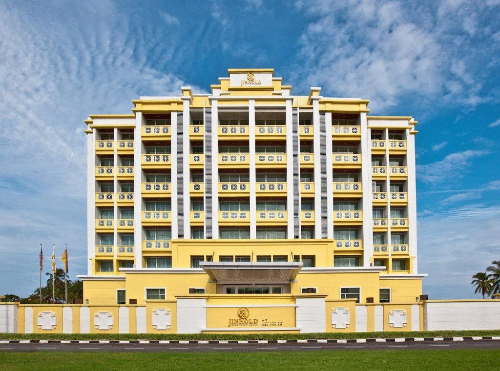 un gran edificio amarillo con un reloj encima en Jinhold Apartment Hotel, en Bintulu