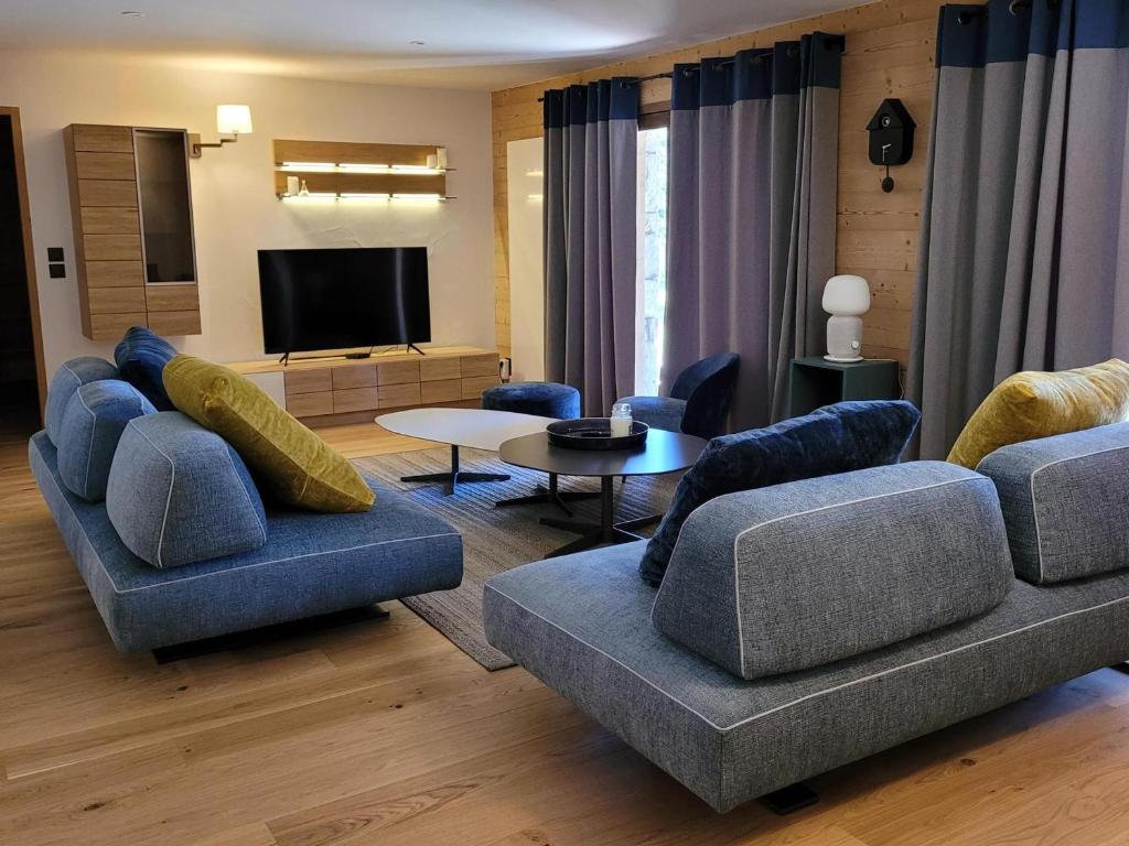 a living room with blue couches and a television at Appartement Montvalezan-La Rosière, 5 pièces, 9 personnes - FR-1-275-184 in La Rosière