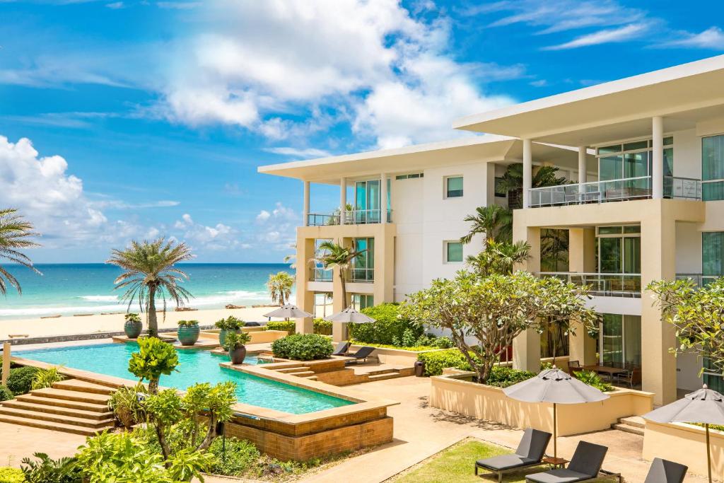 uma vista exterior de um resort com piscina e praia em Happy Apartment on Karon Beach em Praia de Karon
