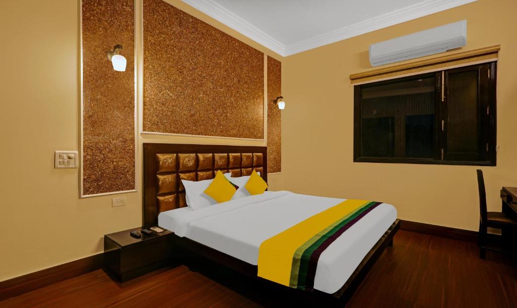 sypialnia z łóżkiem z żółtym i żółtym kocem w obiekcie Itsy By Treebo - Connaught Mews w Nowym Delhi
