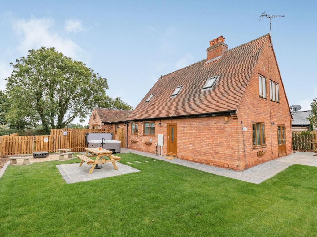 a brick house with a picnic table in the yard at The Old Farmhouse in Longford