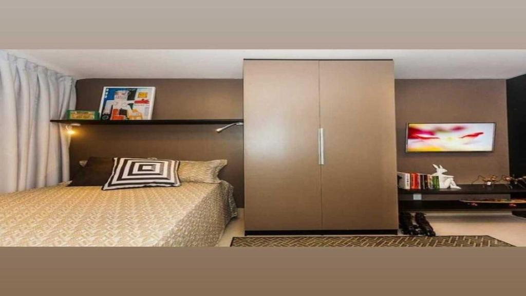 a bedroom with a bed and a large cabinet at Flat em Lagoa Nova, Mobiliado e Aconchegante in Natal