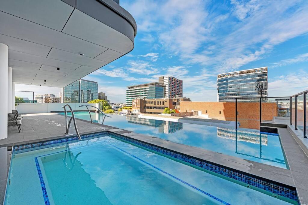 a swimming pool on the roof of a building with a city at Great located unit/Private Balcony, Pool,Gym,Parking in Brisbane