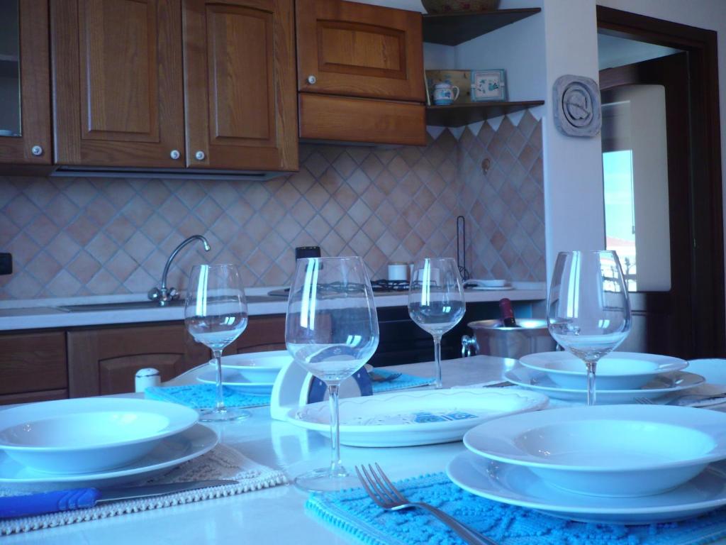 einen Tisch mit Tellern und Weingläsern darauf in der Unterkunft Le Pavoncelle in Alghero