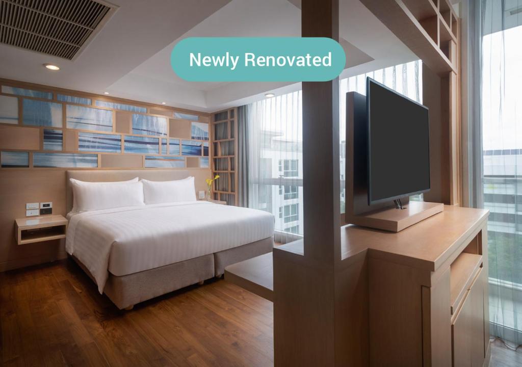 a hotel room with a bed and a tv at Shama Petchburi 47 Bangkok - Former Amari Residences Bangkok in Bangkok