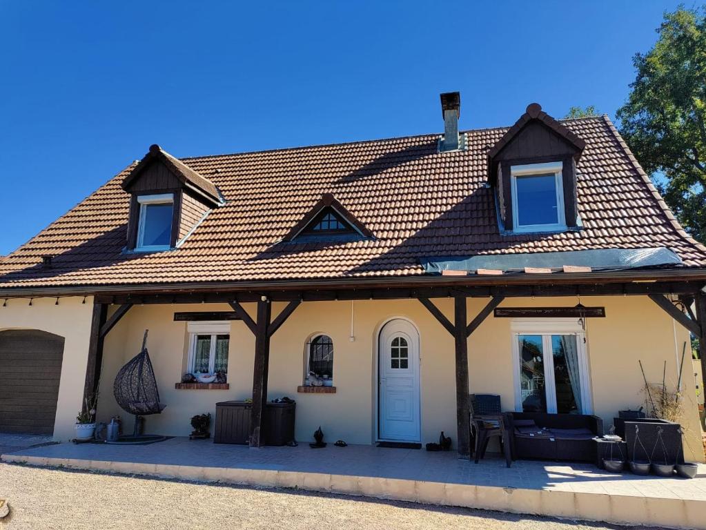 a house with a pitched roof with a porch at Colette Alain Maxime in Lapalisse