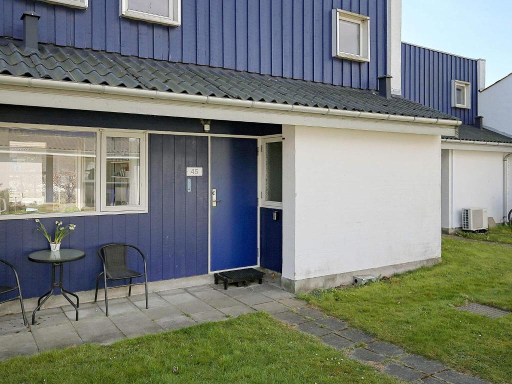Casa azul y blanca con mesa y sillas en Holiday home Væggerløse CCXIII en Bøtø By