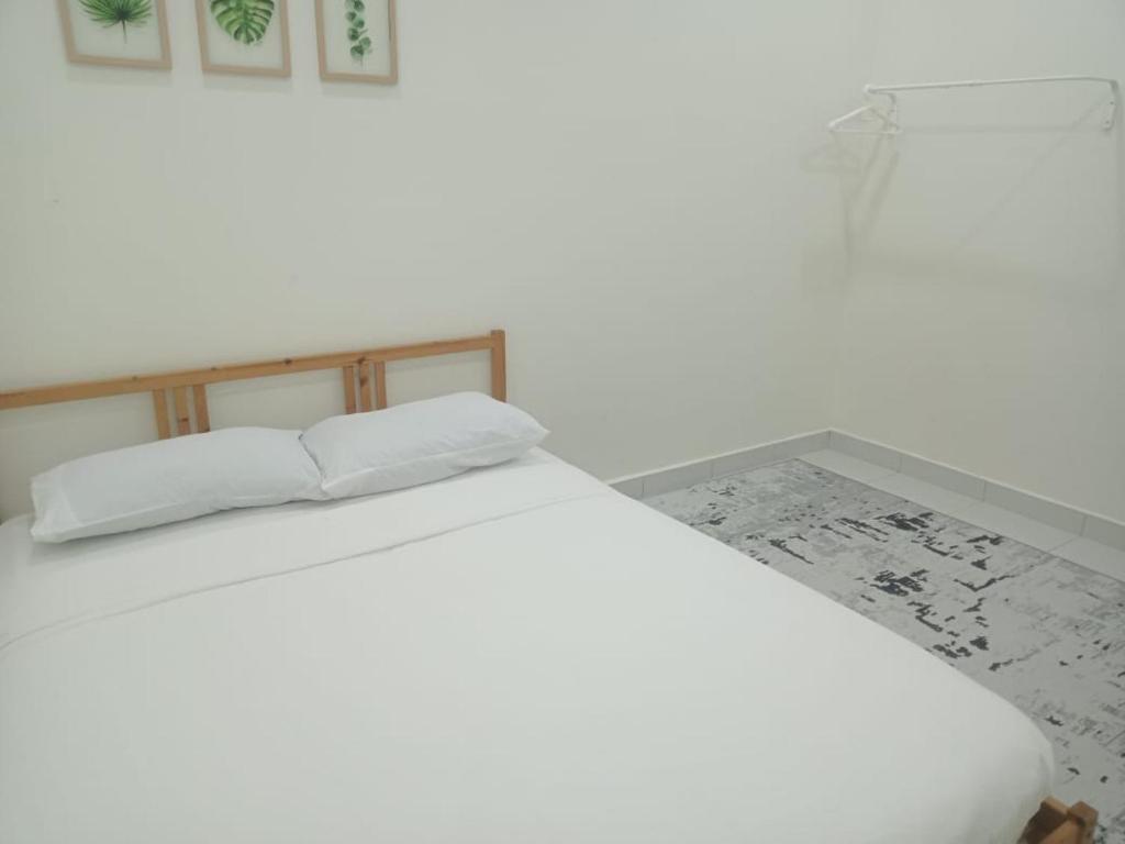 a white bed with two pillows on top of it at ZR D'Chili Homestay, Kemaman in Cukai