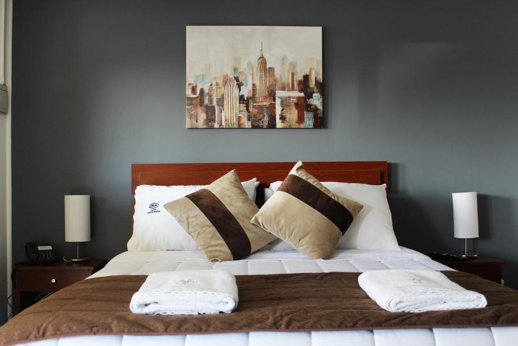 a bedroom with a large bed with two pillows at Hotel Mackenna in Osorno