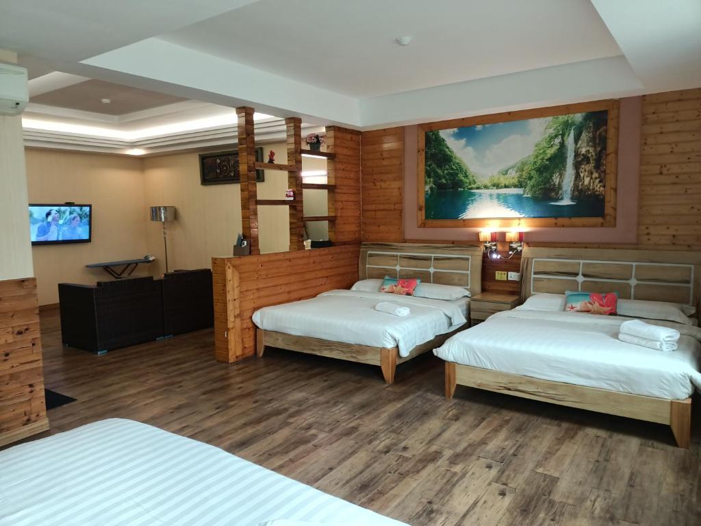 a hotel room with two beds and a flat screen tv at Hotel Balik Pulau in Melaka