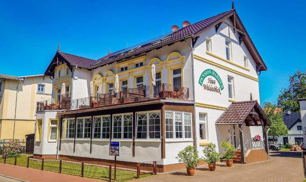 un gran edificio blanco con balcones en una calle en Pension Haus Waldesblick, en Graal-Müritz