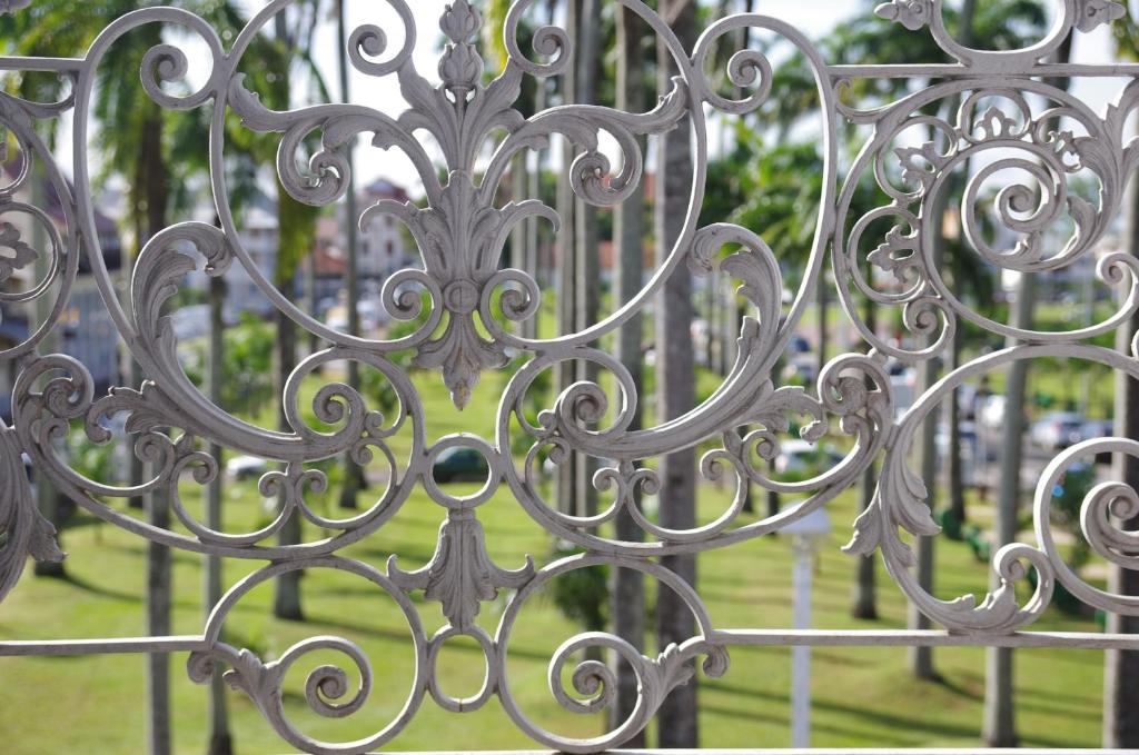 a close up of a metal gate in a park at Hôtel des Palmistes in Cayenne