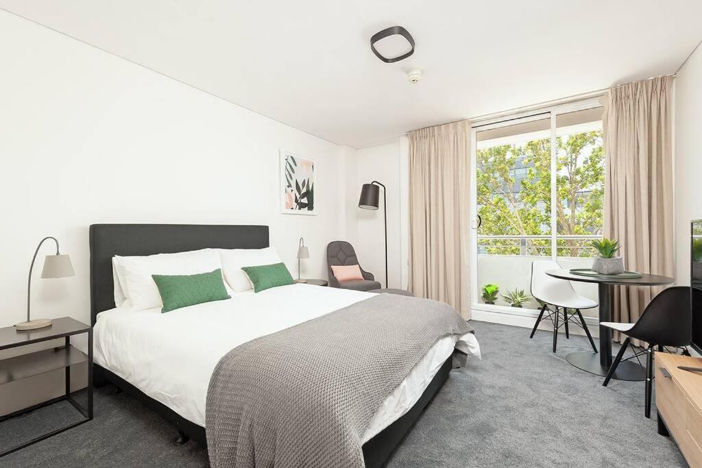 a bedroom with a bed and a desk and a window at MP303 - Studio Apartment, Military Road, Cremorne in Sydney