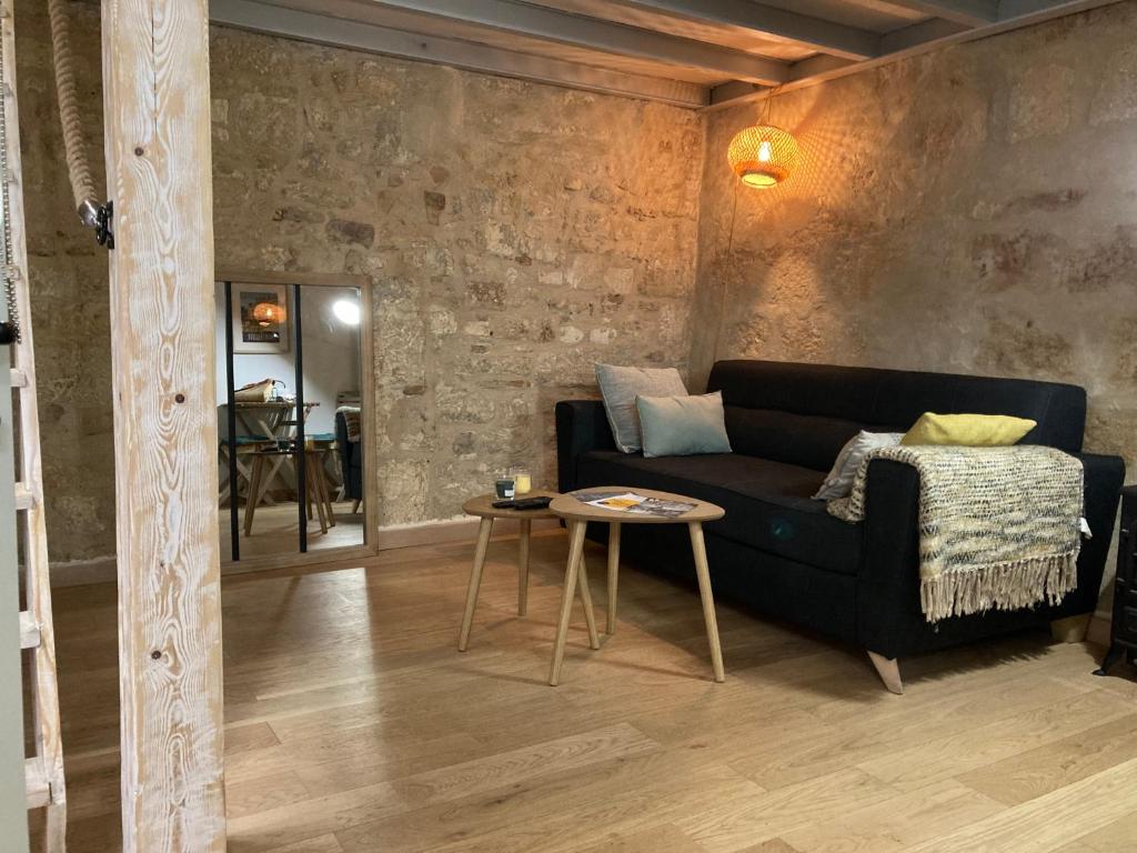 a living room with a black couch and a table at L'Aiguillerie in Montpellier