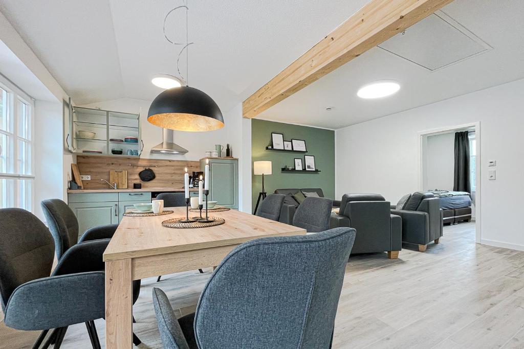 a dining room and living room with a table and chairs at Gut Groß Fedderwarden, Ferienwohnung Mettje in Butjadingen