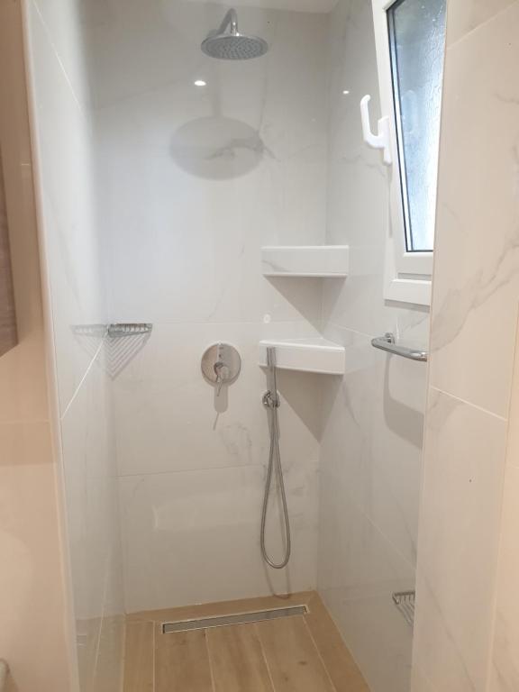 biała łazienka z prysznicem i umywalką w obiekcie Newly Renovated Varkiza Beachside One Bedroom with Large Terrace w Atenach