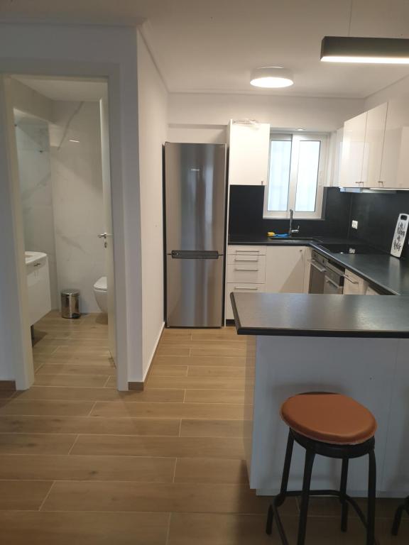 kuchnia z lodówką, blatem i stołkiem w obiekcie Newly Renovated Varkiza Beachside One Bedroom with Large Terrace w Atenach