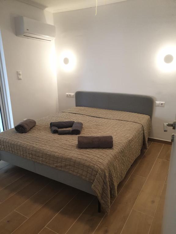 sypialnia z łóżkiem z dwoma brązowymi poduszkami w obiekcie Newly Renovated Varkiza Beachside One Bedroom with Large Terrace w Atenach