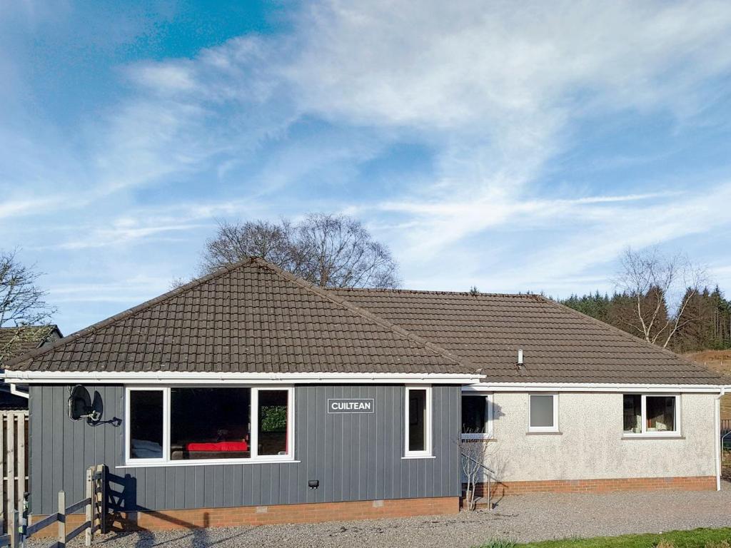 een grijs en wit huis met een garage bij Cuiltean in Gairlochy