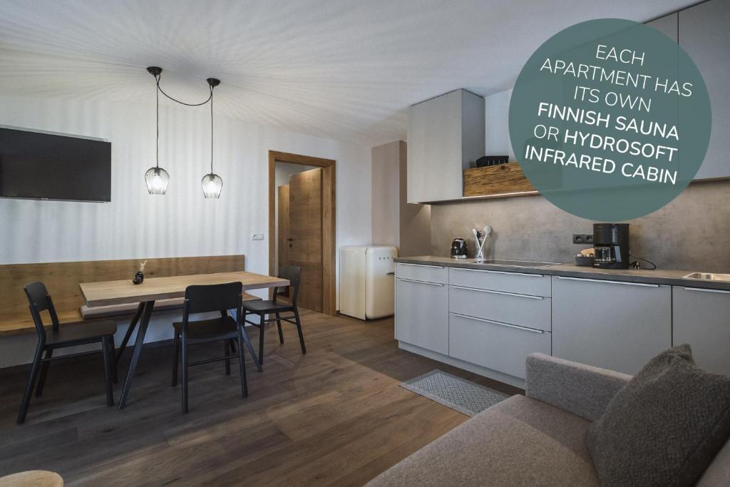 a kitchen and dining room with a table and chairs at Apartments Koflhaus in Cadipietra