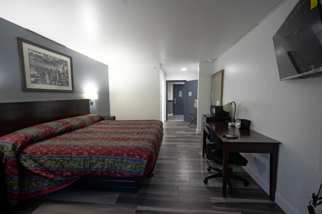 una camera con letto, scrivania e TV di Greenwoods inn & Suites a Berlin