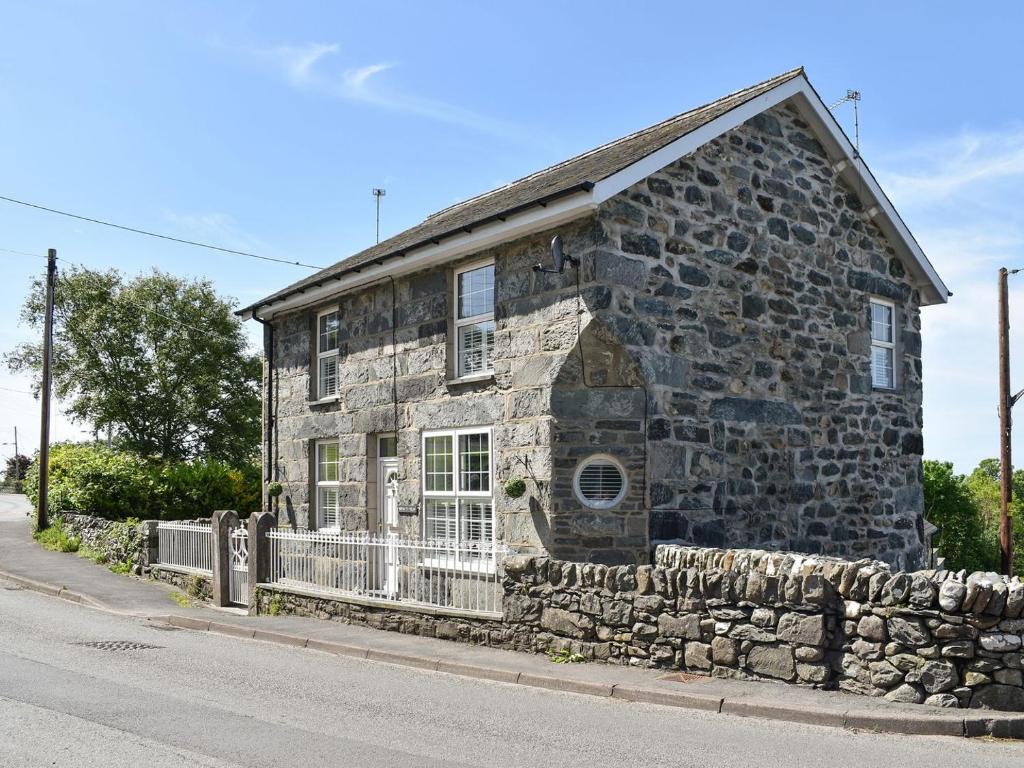 an old stone house on the side of a street at Bryn Y Felin in Dyffryn